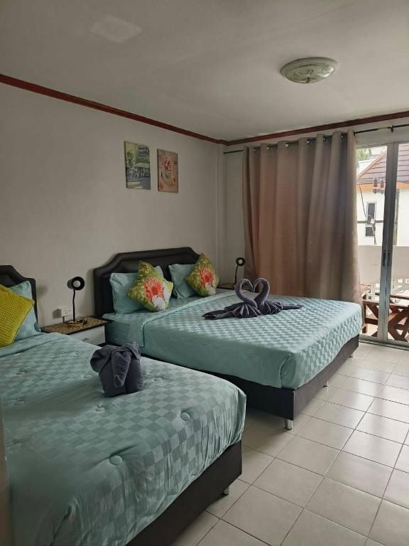 a bedroom with two beds and a balcony at We Love Kata in Kata Beach