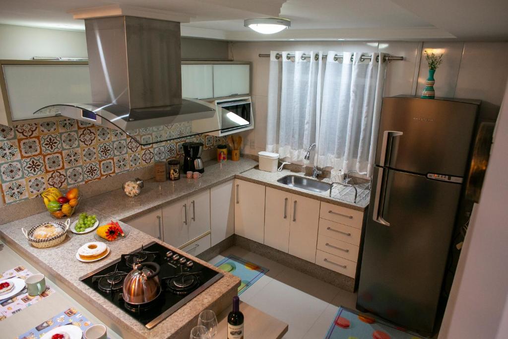 a kitchen with a refrigerator and a stove top oven at B&B Apartamento Completo e Decorado com 3 Quartos in São José dos Pinhais