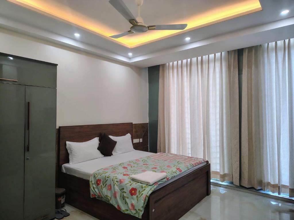 Un dormitorio con una cama con ventilador de techo. en Roop Mahal, en Jāmb