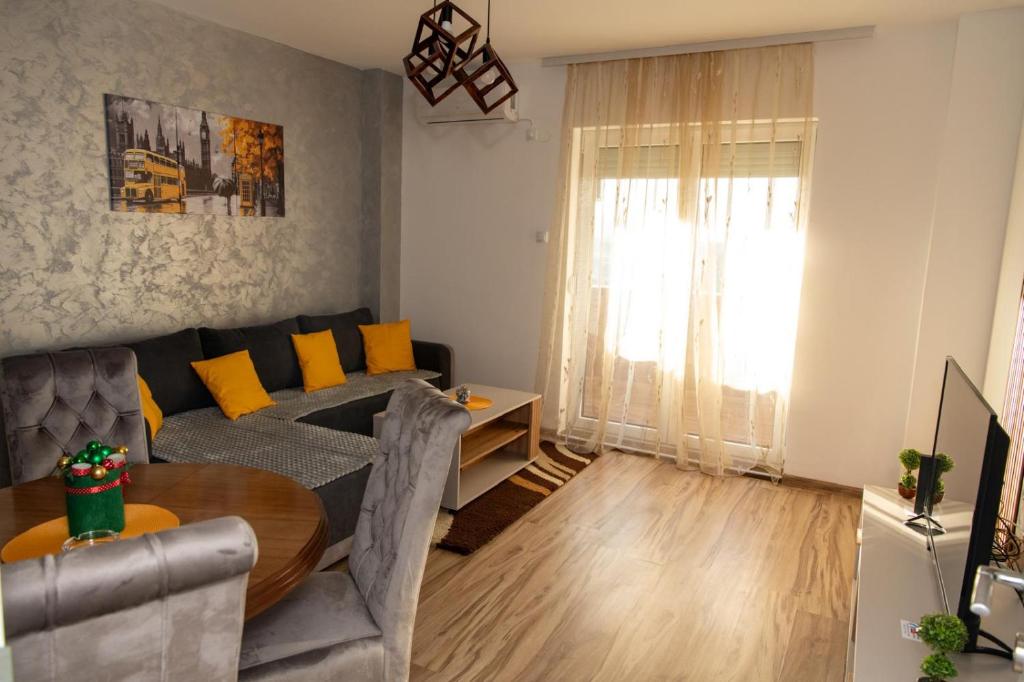 una sala de estar con un sofá y una mesa en Apartmani Loznica Premia, en Loznica
