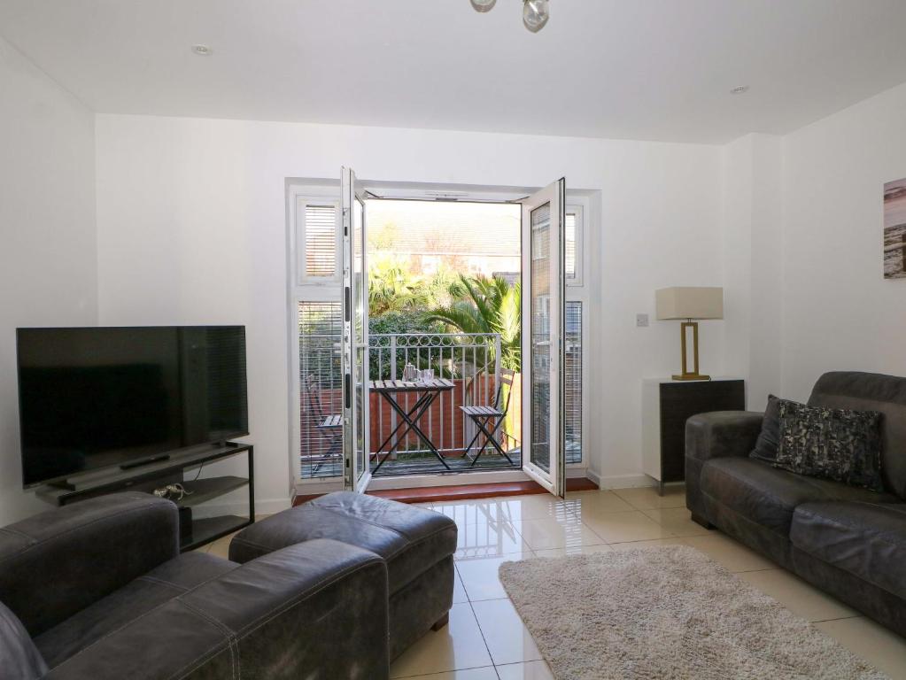 a living room with a couch and a flat screen tv at Harbour Way in Shoreham-by-Sea
