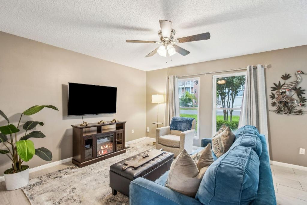 a living room with a blue couch and a tv at Pet Friendly Beach Retreat - Fernandina Shores - 6355 in Fernandina Beach