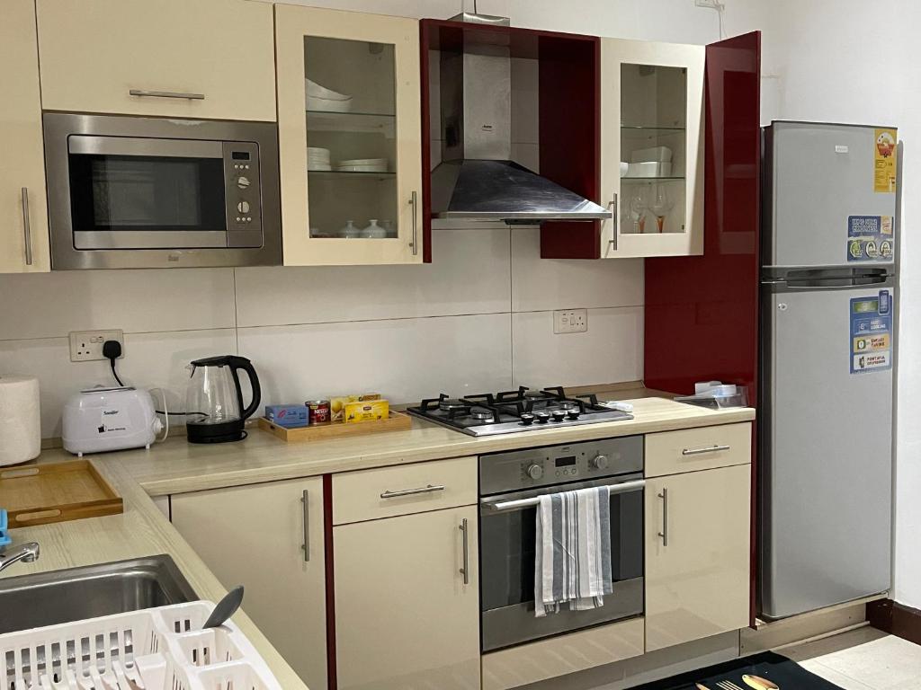 una cocina con estufa y refrigerador en Home in Airport Residential- 2 mins from airport, en Accra
