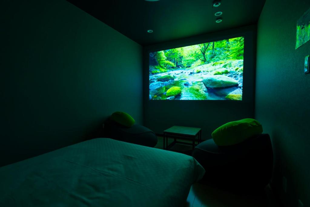 a bedroom with a bed and a flat screen tv at Homey Inn SANNO in Kyoto