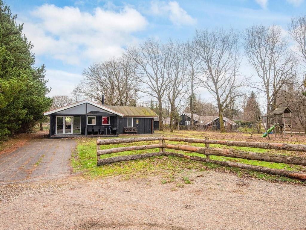 a small house with a fence in a field at 4 star holiday home in Ansager in Ansager