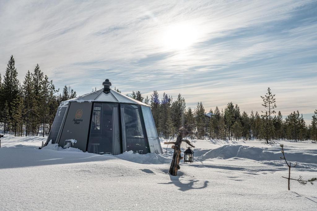 uma pessoa em pé na frente de uma tenda na neve em Hotel Glamping Gällivare - Laponia Sky Hut - Norrbotten - Lappland - Northern Lights em Koskullskulle