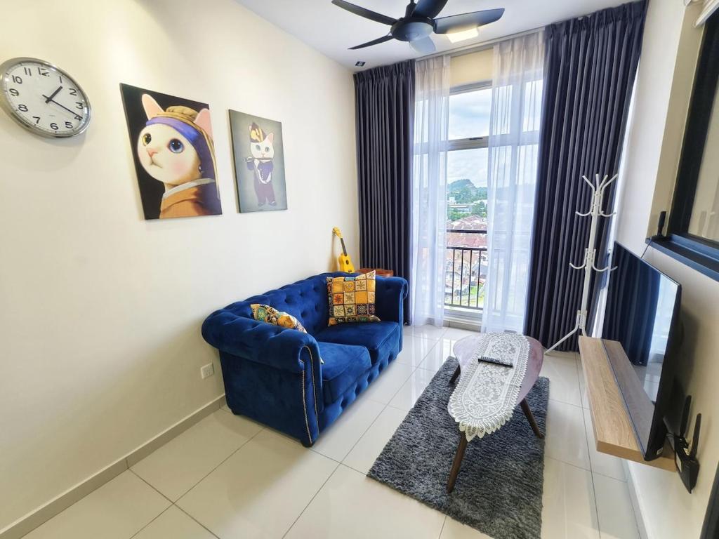 Midas 4pax Offer 20 Rebate for 3day Stay, Free Netflix I Pet Friendly في ماساي: غرفة معيشة بها أريكة زرقاء وساعة