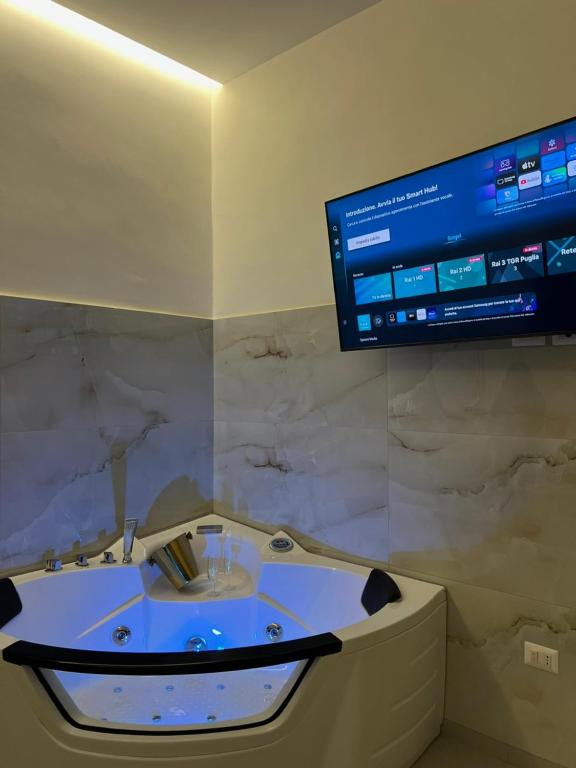a bathroom with a bath tub with a tv on the wall at Ad Astra in Brindisi
