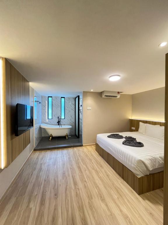 a hotel room with a bed and a bath tub at Alva Boutique Chalet Pangkor in Pangkor
