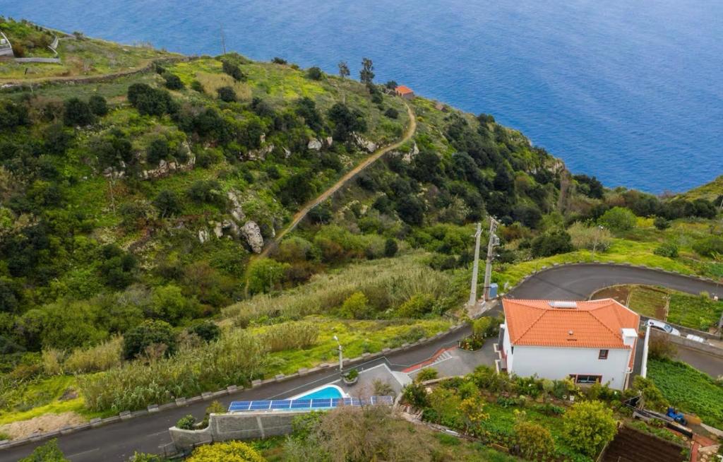 een huis aan de zijkant van een heuvel met een weg bij Jardim do mar luxury in Jardim do Mar