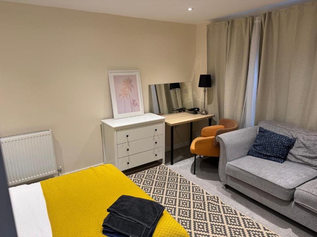 a bedroom with a bed and a desk and a couch at Bath rd villa in Keynsham