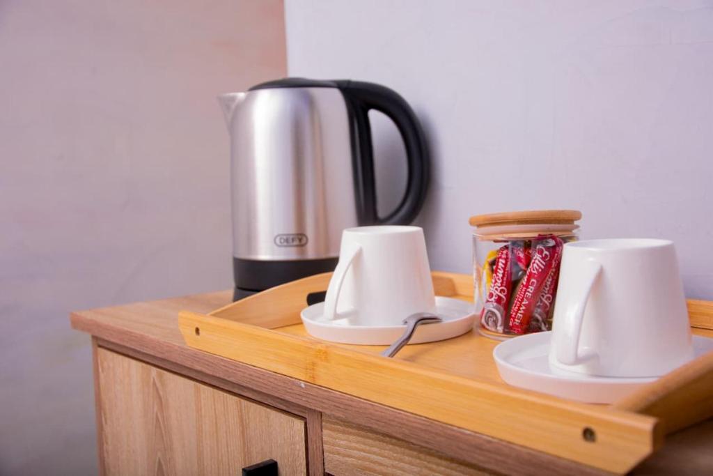 eine Holztheke mit einer Kaffeemaschine und Tassen darauf in der Unterkunft Meriam Base Lodge in Kempton Park