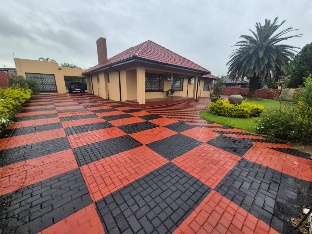 a house with a checkered floor in the driveway at Ithonsi Guesthouse in Kempton Park