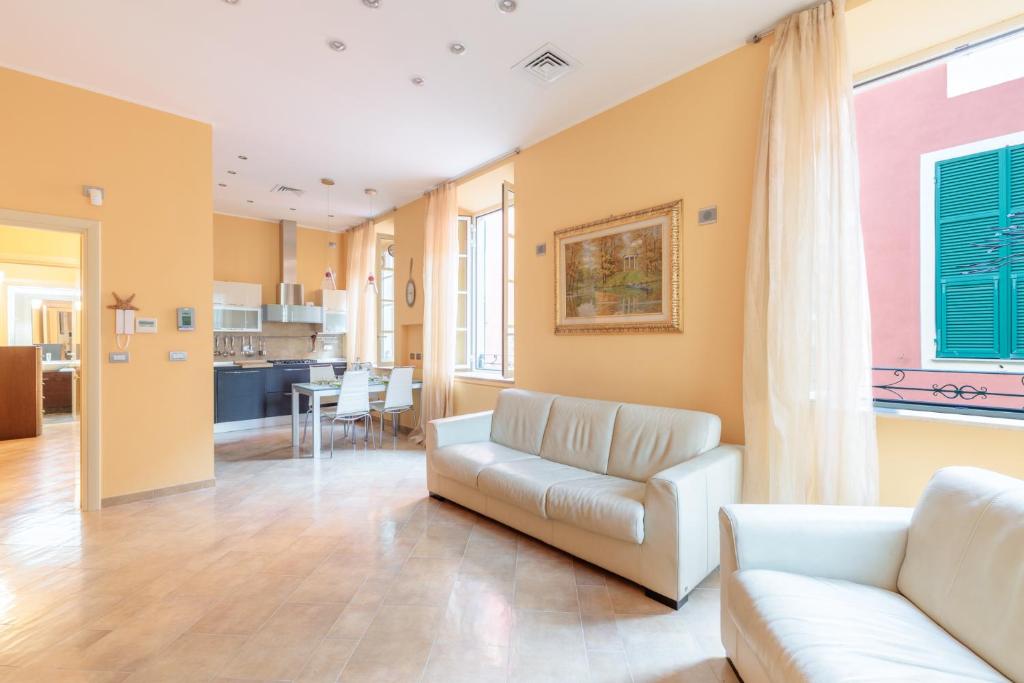 een woonkamer met een bank en een keuken bij Hostdomus - Il Maestrale Apartment in Alassio