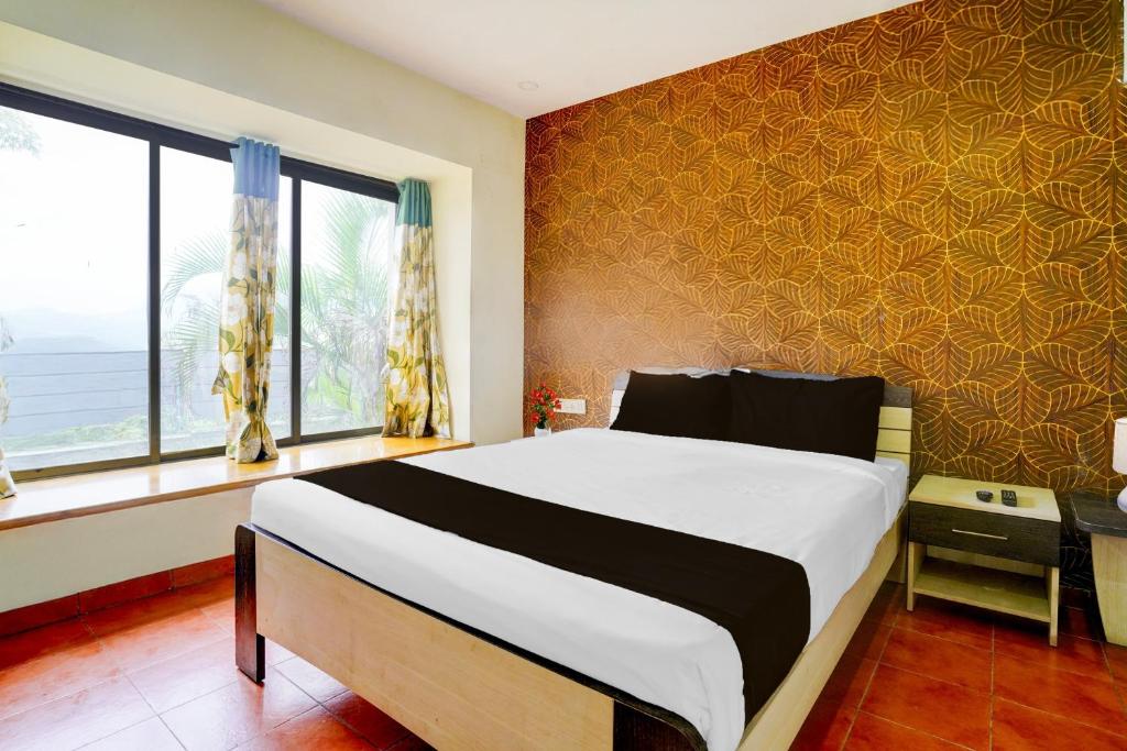 Un dormitorio con una cama grande y una ventana. en Palette by CheckIn Igatpuri Formerly Bodh Valley Resort, en Igatpuri