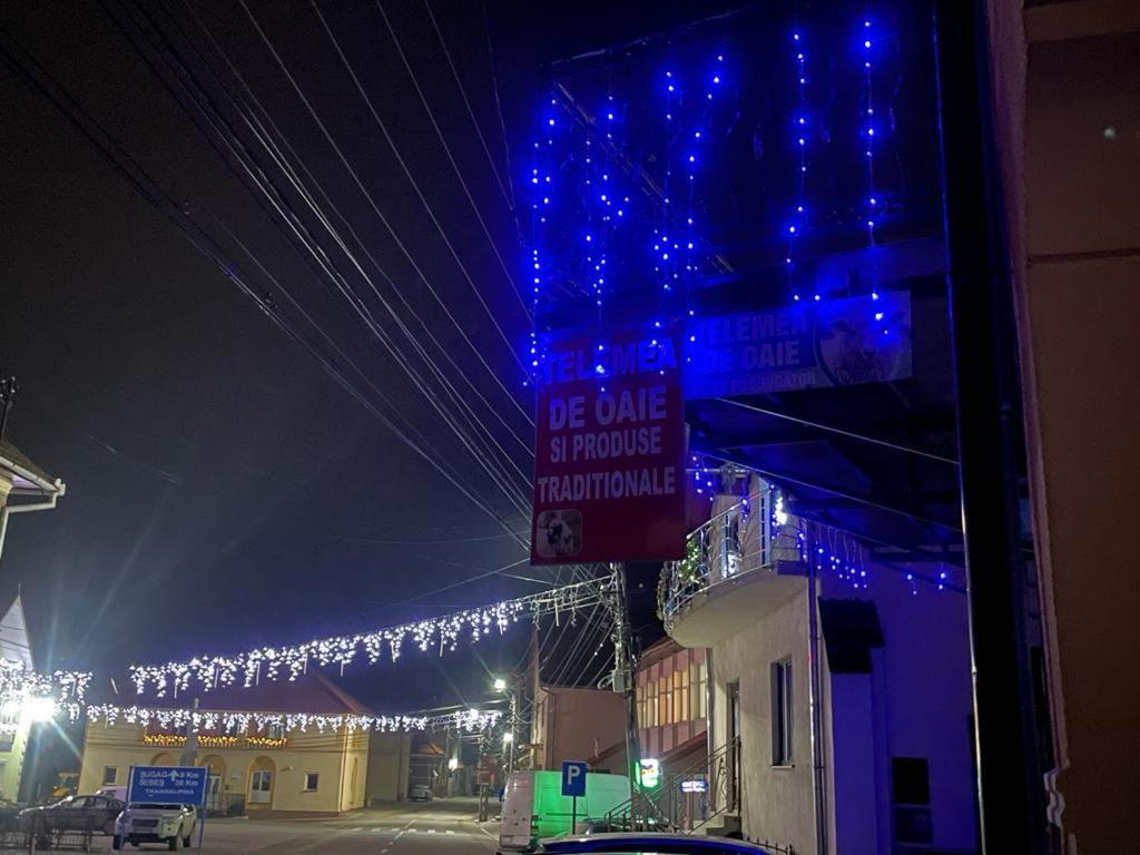 eine beleuchtete Straße mit blauen Lichtern und einem Gebäude in der Unterkunft Casa Birsan in Jina