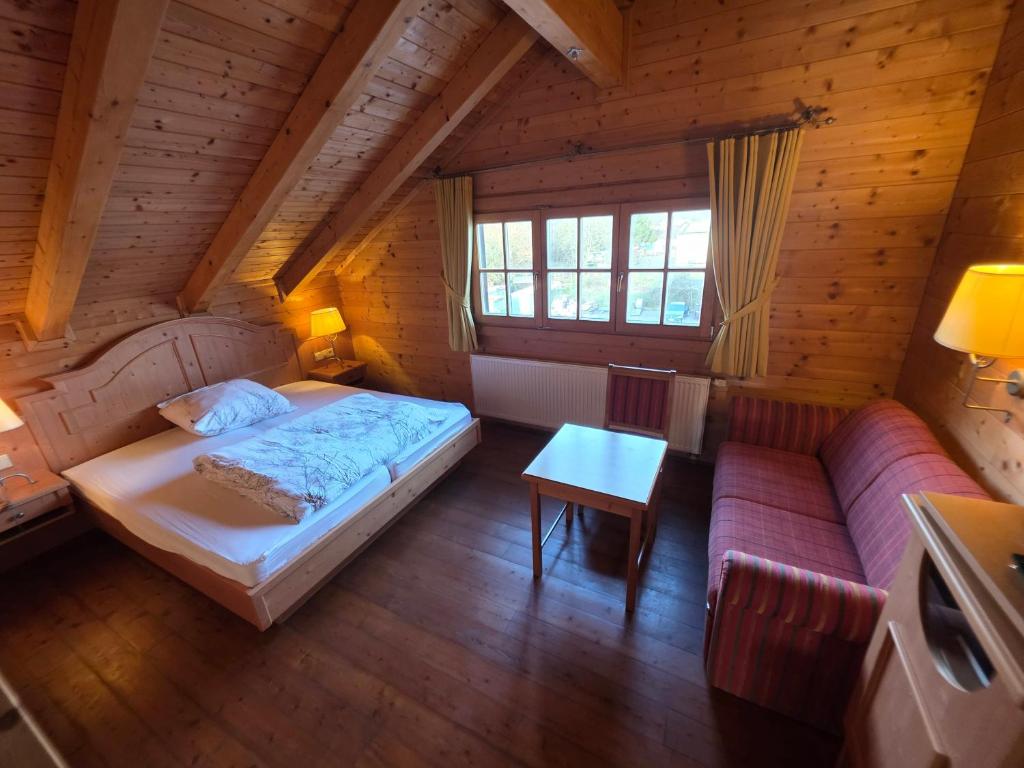 a bedroom with a bed and a couch in a room at JOHN'S Pension in Saarwellingen