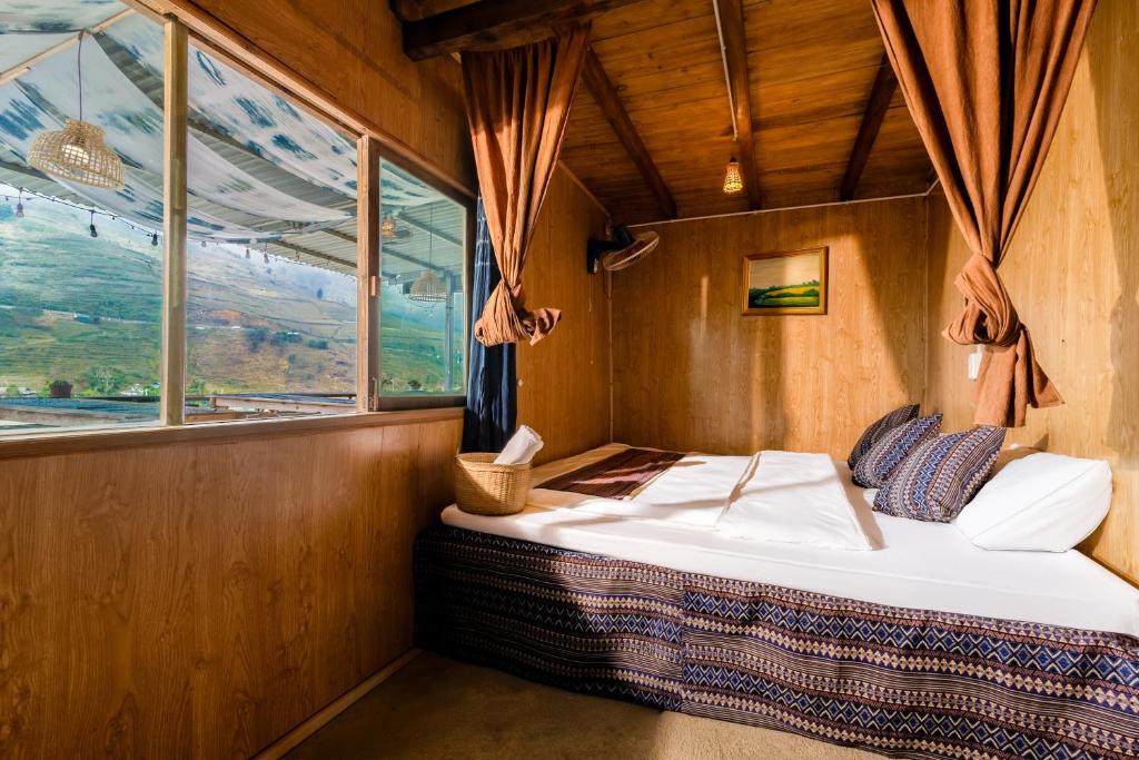 a bed in a room with a window at PaoDzung homestay Tả Van in Sa Pa