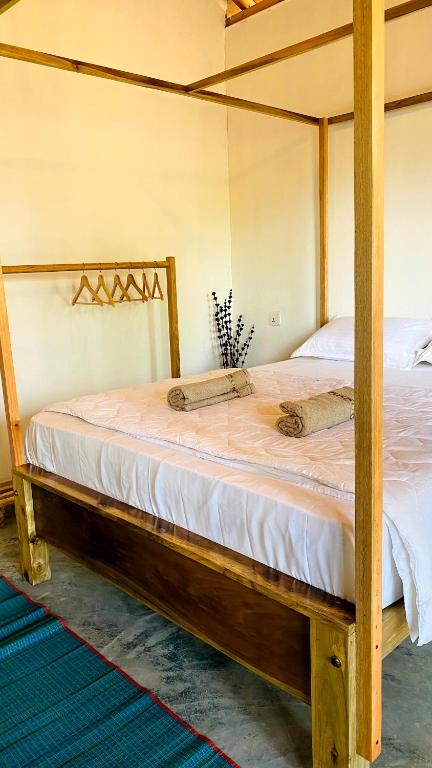 Cama en habitación con marco de madera en Inara Stay, en Arugam Bay
