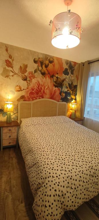 a bedroom with a bed with a flower mural on the wall at Cheltenham town centre with parking space in Cheltenham