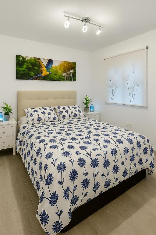 a bedroom with a bed with a blue and white comforter at apartamento sevilla enzo in Seville