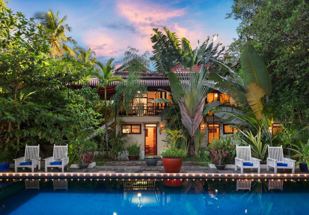 a house with a swimming pool in front of it at The Cockatoo Nature Resort & Spa in Siem Reap