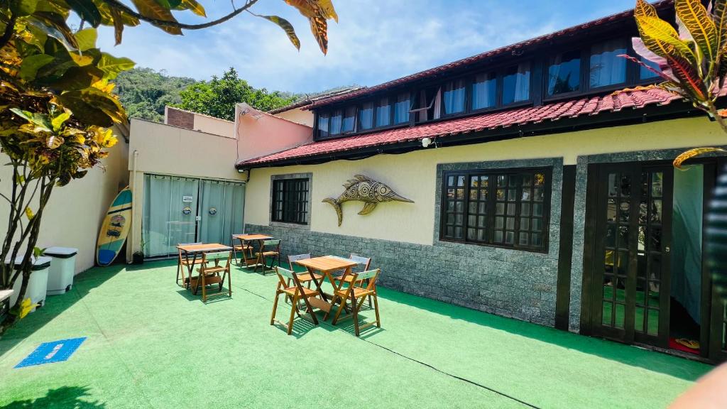 eine Terrasse mit Tischen und Stühlen vor einem Gebäude in der Unterkunft Pousada Zen in Angra dos Reis