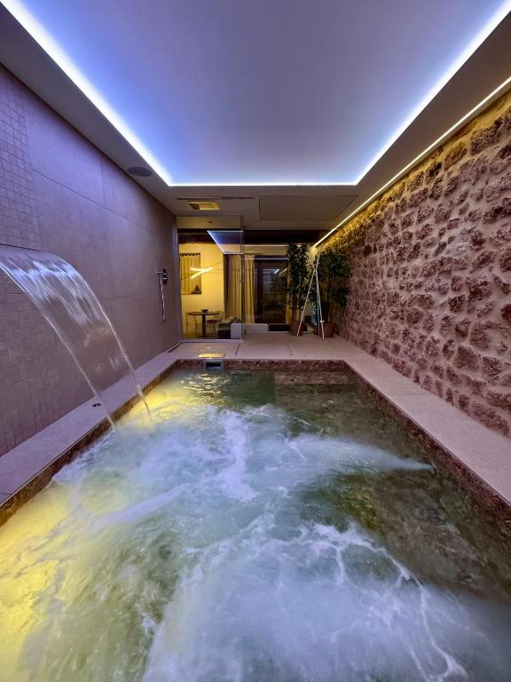 a hot tub in a room with a stone wall at Loft SPA Massa Marittima in Massa Marittima