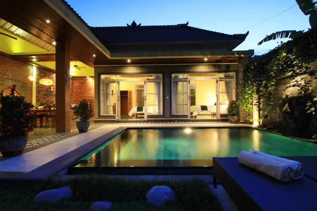 a swimming pool in the backyard of a house at Villa Ketut Kartika in Ubud