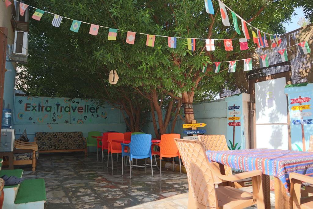 eine Terrasse mit bunten Stühlen, Tischen und Fahnen in der Unterkunft Extra Traveller in Aqaba