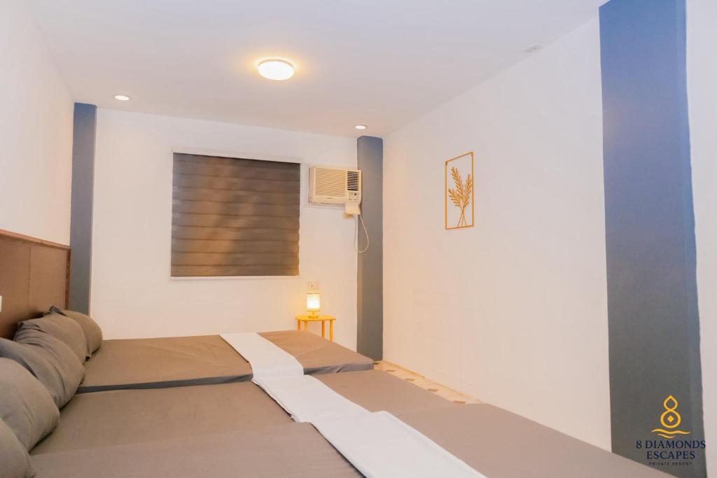 Cette chambre dispose d'un lit et d'une peinture murale. dans l'établissement 8 Diamonds Escapes, à Calamba