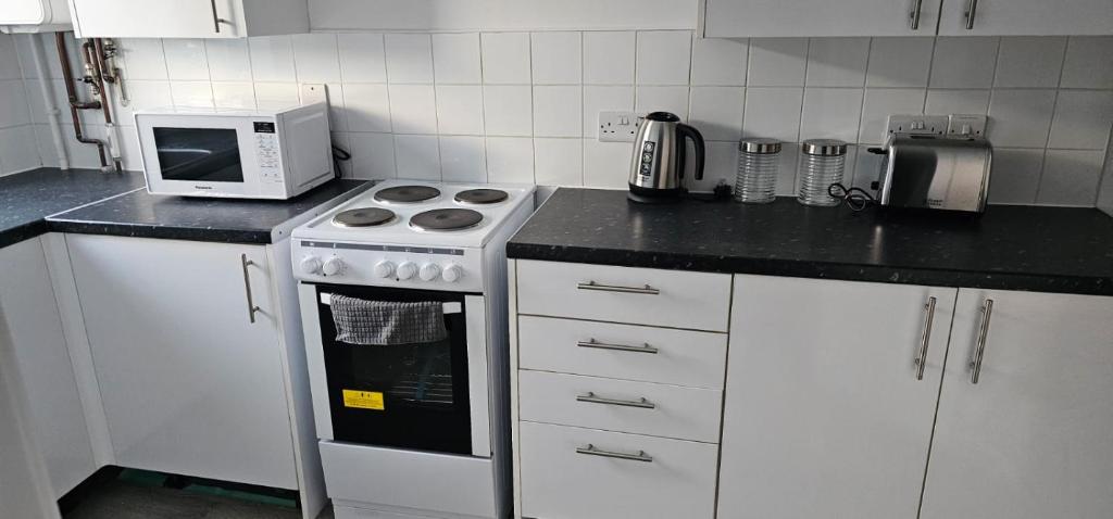 NewTown Home Host 4-5 Guests في Brettell Lane: مطبخ مع موقد وميكروويف