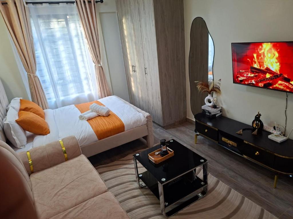 ein Schlafzimmer mit einem Bett, einer Couch und einem Spiegel in der Unterkunft Staycation with Ryn in Ruaka