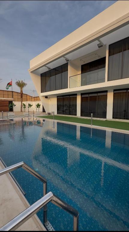 a large swimming pool in front of a building at Alma chalets in Aş Şarīḩ