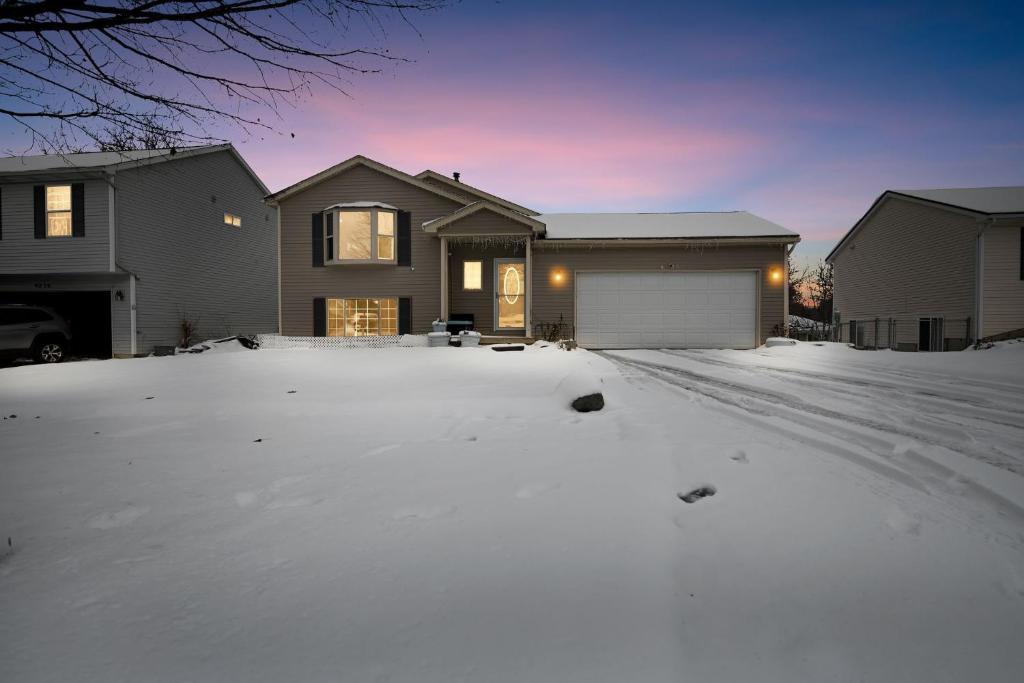 eine schneebedeckte Auffahrt vor einem Haus in der Unterkunft Bright 4BR Near MSU & Downtown home in Packard