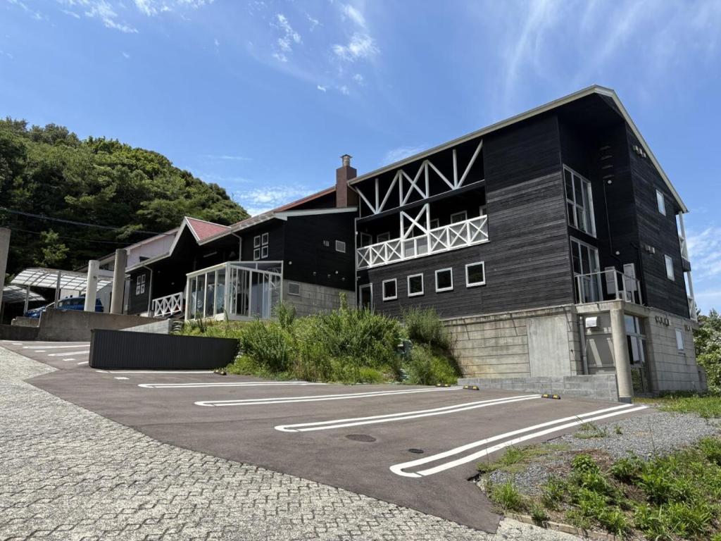 a black building with a parking lot in front of it at Peace INN HAGI in Hagi