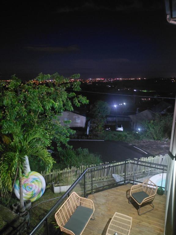 a balcony with chairs and a view at night at Villa Fatjo in Le Tampon