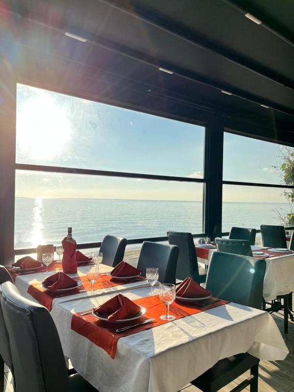 a dining room with a table and chairs and the ocean at Deniz Hotel Kumburgaz in Büyükçekmece
