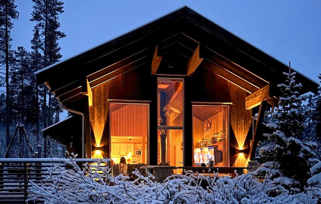 una cabaña de madera en la nieve por la noche en Nice Home In Tinn Austbygd With Sauna, en Luråsgrendi