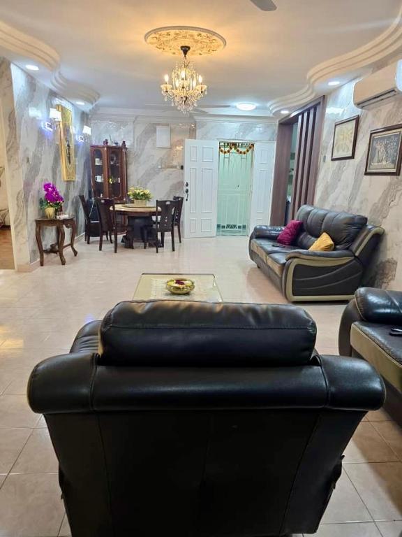 un soggiorno con un divano in pelle nera e un tavolo di Venice Hill Condo Homestay a Kampong Baharu Cheras Batu Sembilan