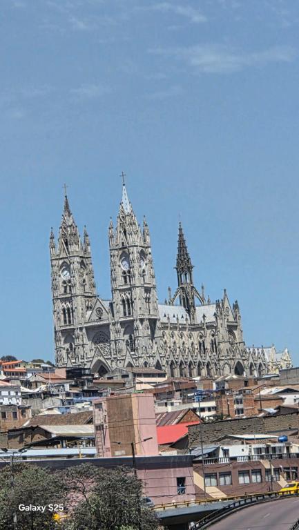 a large building with a clock tower in a city at Hostal Marín Central - Quito in Quito