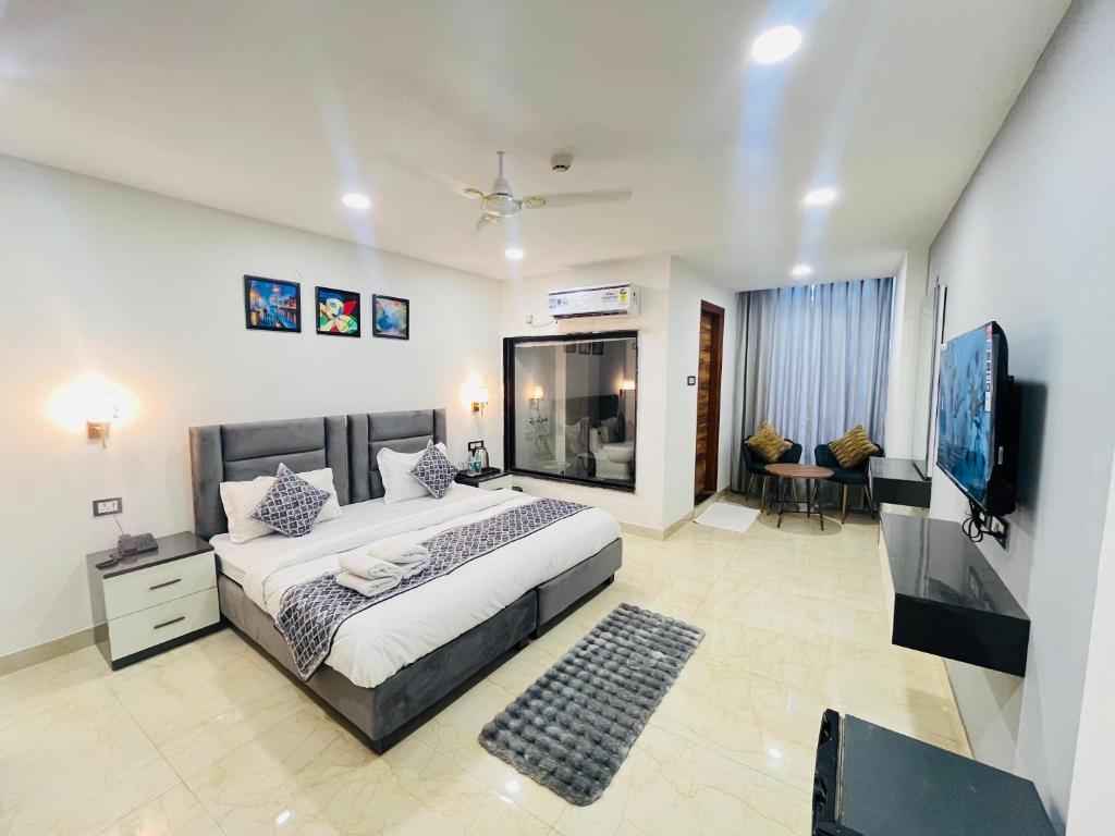 a bedroom with a bed and a flat screen tv at Hotel Aroma - Chattarpur in Gurgaon