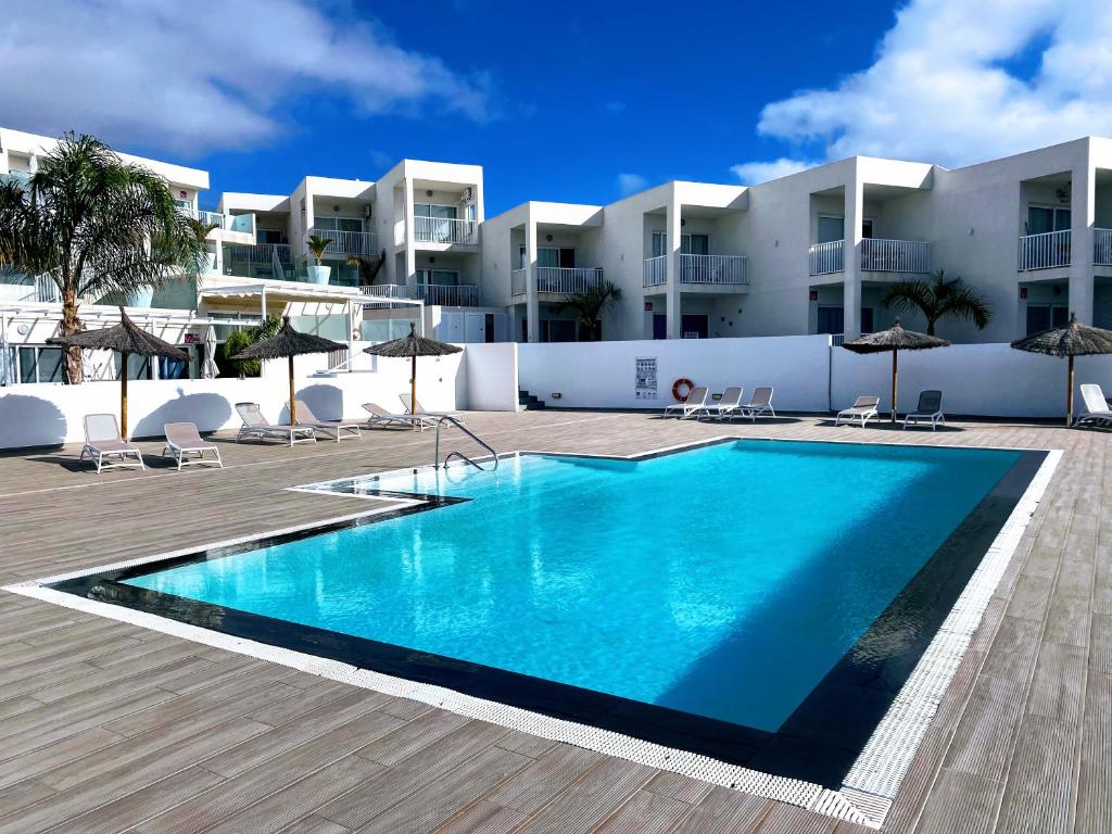 ein Schwimmbad vor einem Gebäude in der Unterkunft Luxury Senator Apartments in Costa Teguise