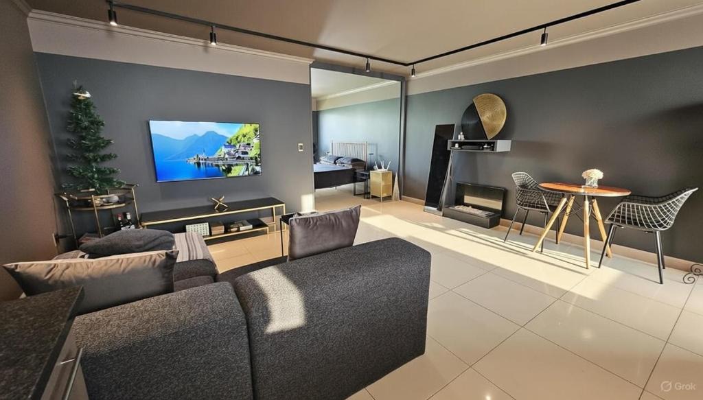 uma sala de estar com um sofá e uma TV na parede em Oceans Deep at Lagoon Terrace - Knysna! em Knysna
