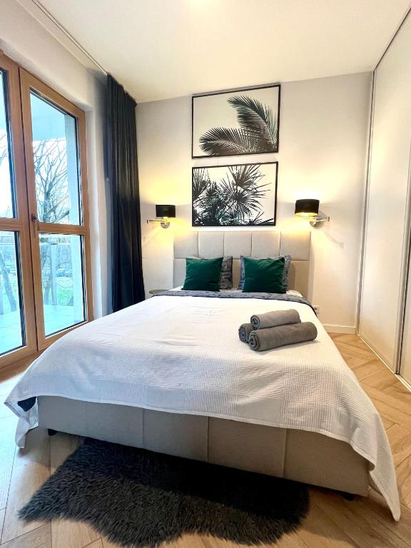 a bedroom with a large white bed with green pillows at Rudnickiego, Fort Bema, free parking by Cosmo Spirit in Warsaw