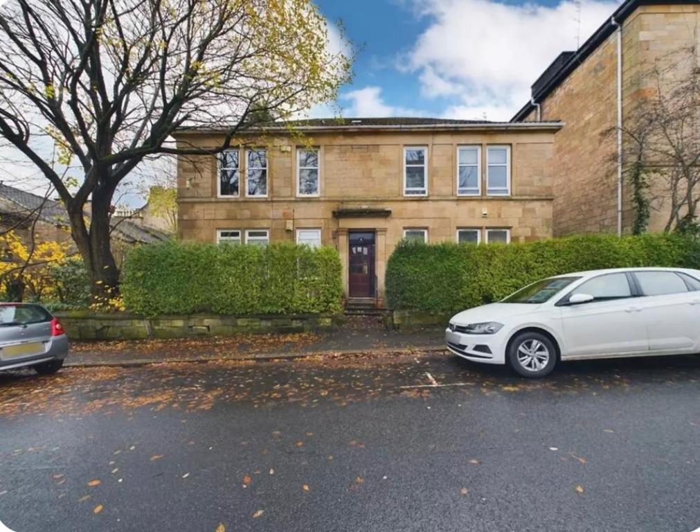 una casa con dos coches estacionados frente a ella en Apartment near Glasgow Airport, en Paisley