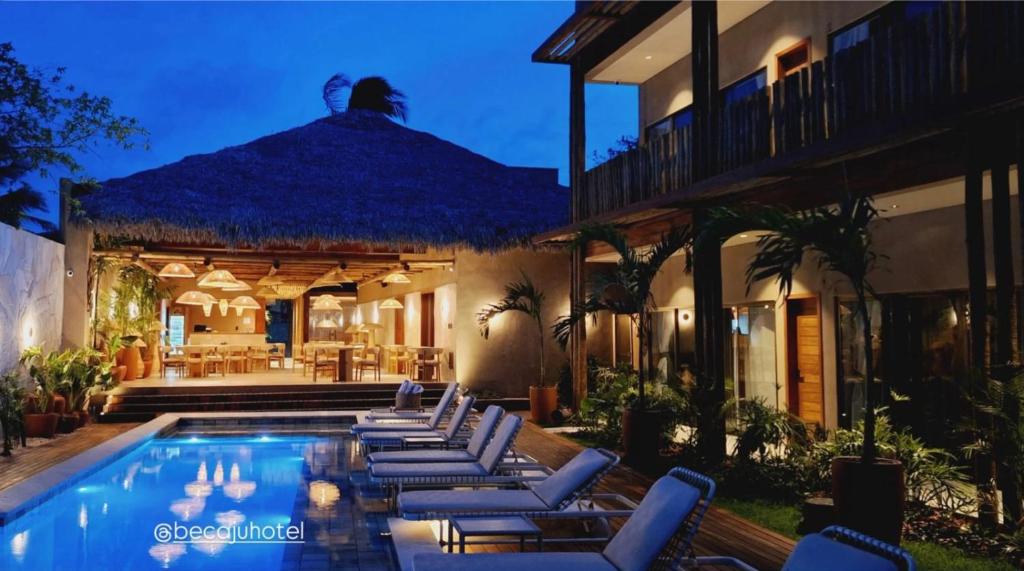 a villa with a swimming pool and lounge chairs at Be Caju Hotel in Barra Grande