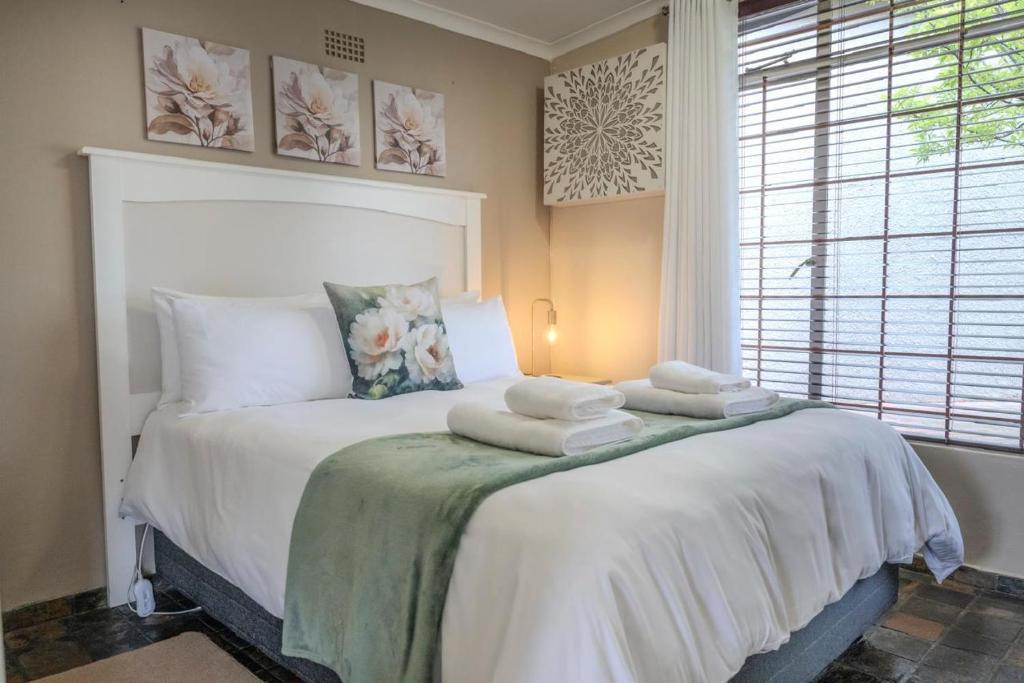 Un dormitorio con una cama con toallas. en Summer House, en Harrismith