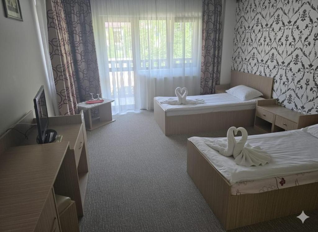 a hotel room with two beds and a window at Cornu Complex Mem in Campina