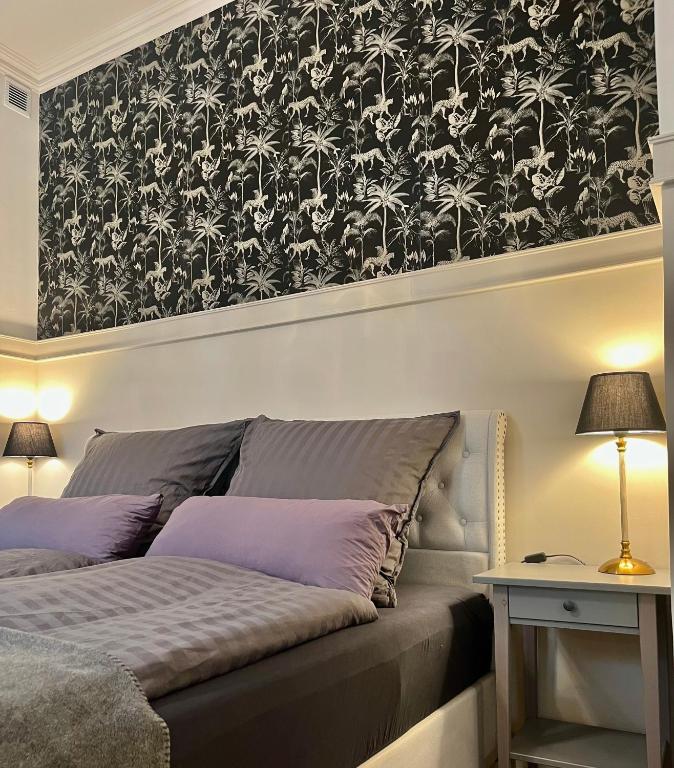 a bedroom with a bed with a black and white wallpaper at der Elbe so nah 2 in Dömitz
